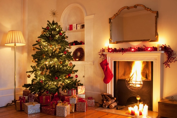 Geschmückter Weihnachtsbaum neben Kamin.